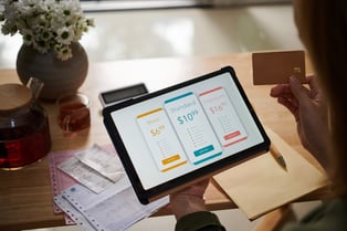 Person using a tablet to choose between basic, standard, and premium billing plans